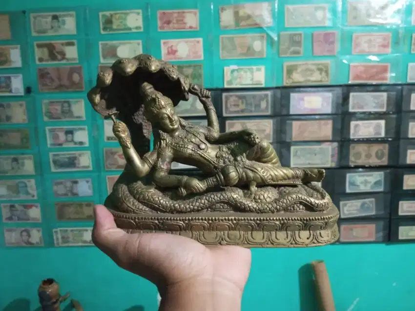 Patung dewa krisna dengan ular kepala tuju bahan kuningan
