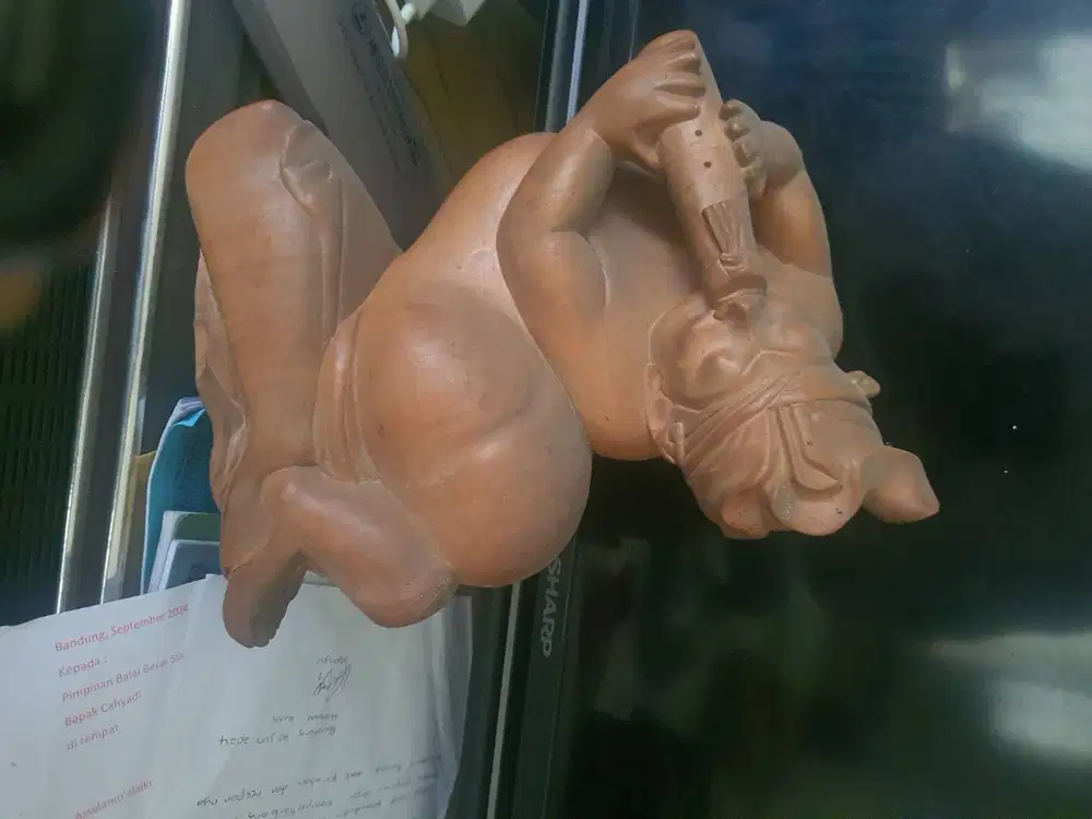 Patung laki-laki Bali sedang meniup seruling