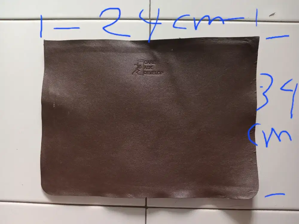 Bahan kulit sintetis warna coklat ada tulisan CARE ASK DEVELOP