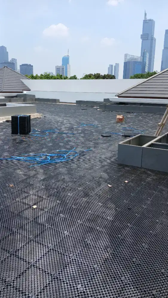 Pemasangan Drainase Hitam Lapisan Rumput Sintetis