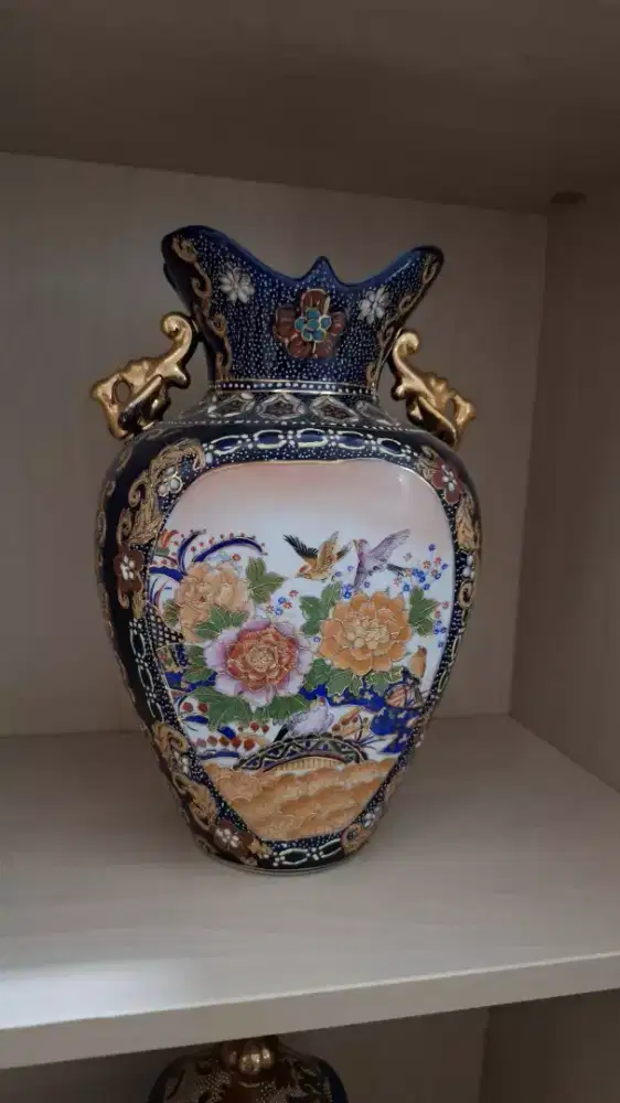 Porcelain vase blue background multicolored designs gold accents