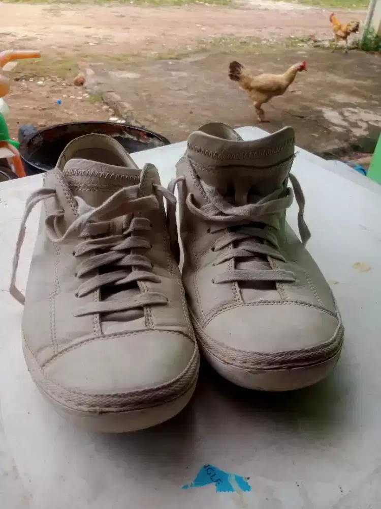 sepatu bekas kasual bertali kulit berwarna krem dari Clarks. 