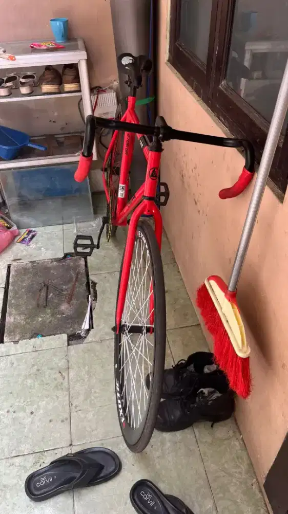 Sepeda fiksi berwarna merah stang bandot rem torpedo