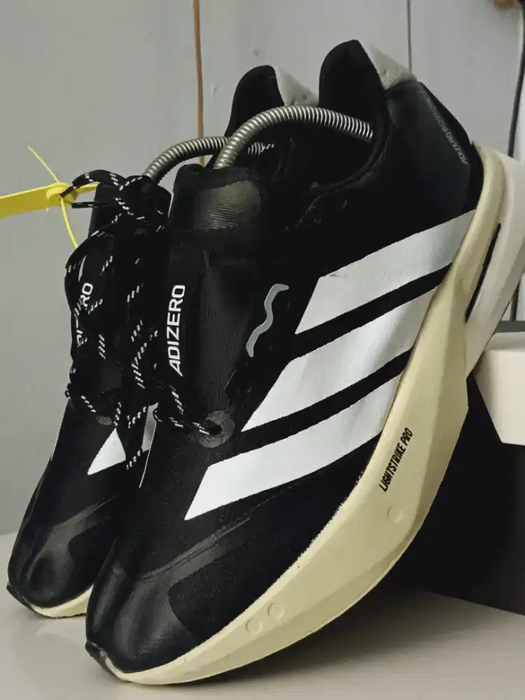 Adidas Adizero Boston 13 running shoes in black, white, and grey. 