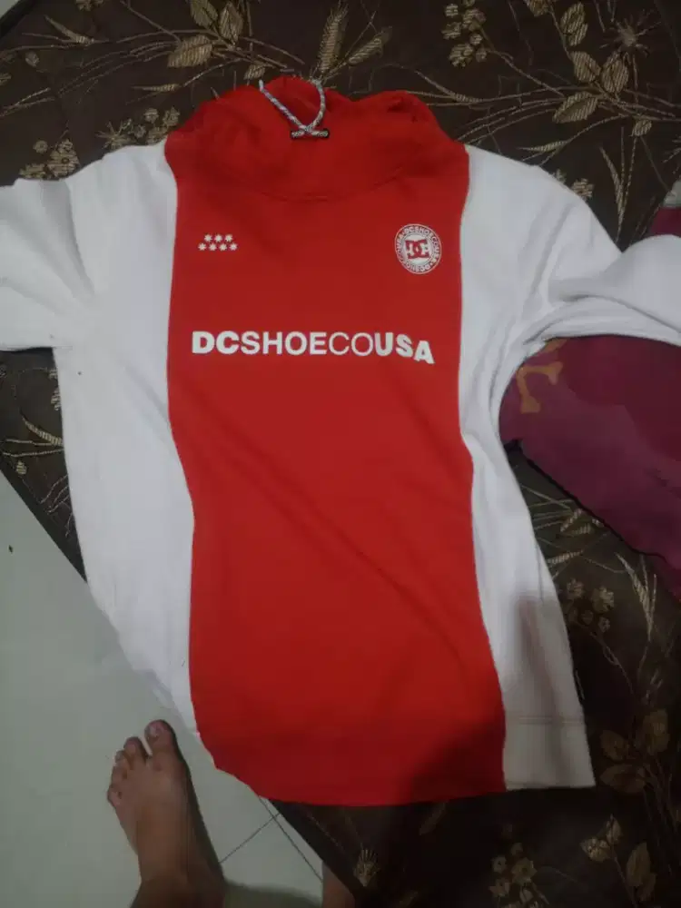 Jual hoodie DC Shoes berwarna merah dan putih.