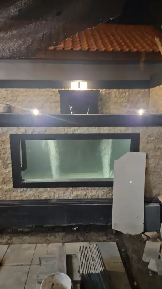 Mengerjakan dekorasi kolam koi dan tebing