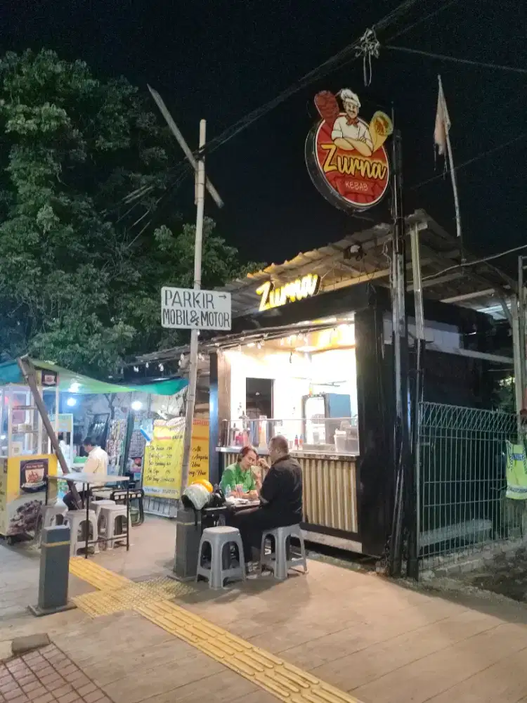 Karyawati jaga booth makanan dan minuman