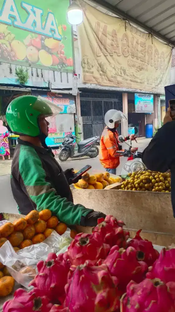 karyawan jaga kios buah
