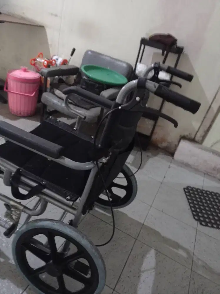 Kursi roda travelling bisa dilipat. Dilengkapi dengan rem dan sabuk.