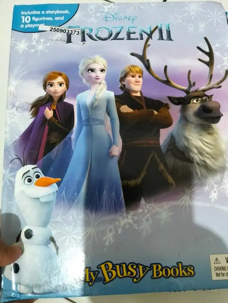 Buku dan figur Elsa membaca sambil bermain