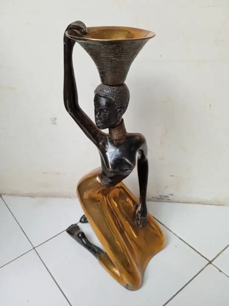 Patung bergaya wanita Afrika yang sedang berlutut