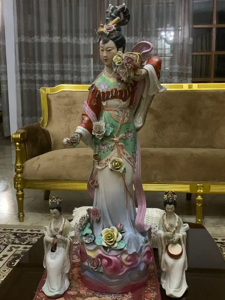 large statue of a Chinese lady surrounded by two smaller musician figu