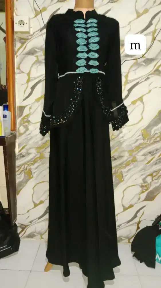 Gamis berwarna hitam dasar ini menghadirkan kesan kemewahan