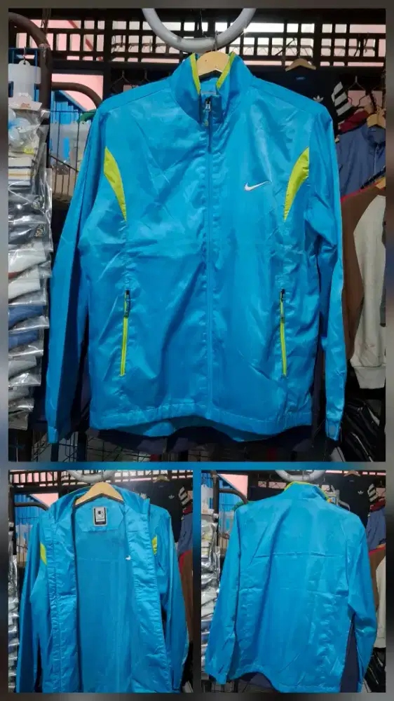 Nike Windbreaker Jacket berwarna biru muda dengan aksen hijau neon