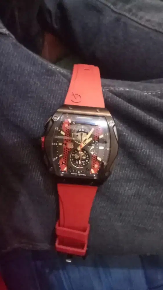 Alexandre Christie seri AC 6608 dengan tali karet berwarna merah.