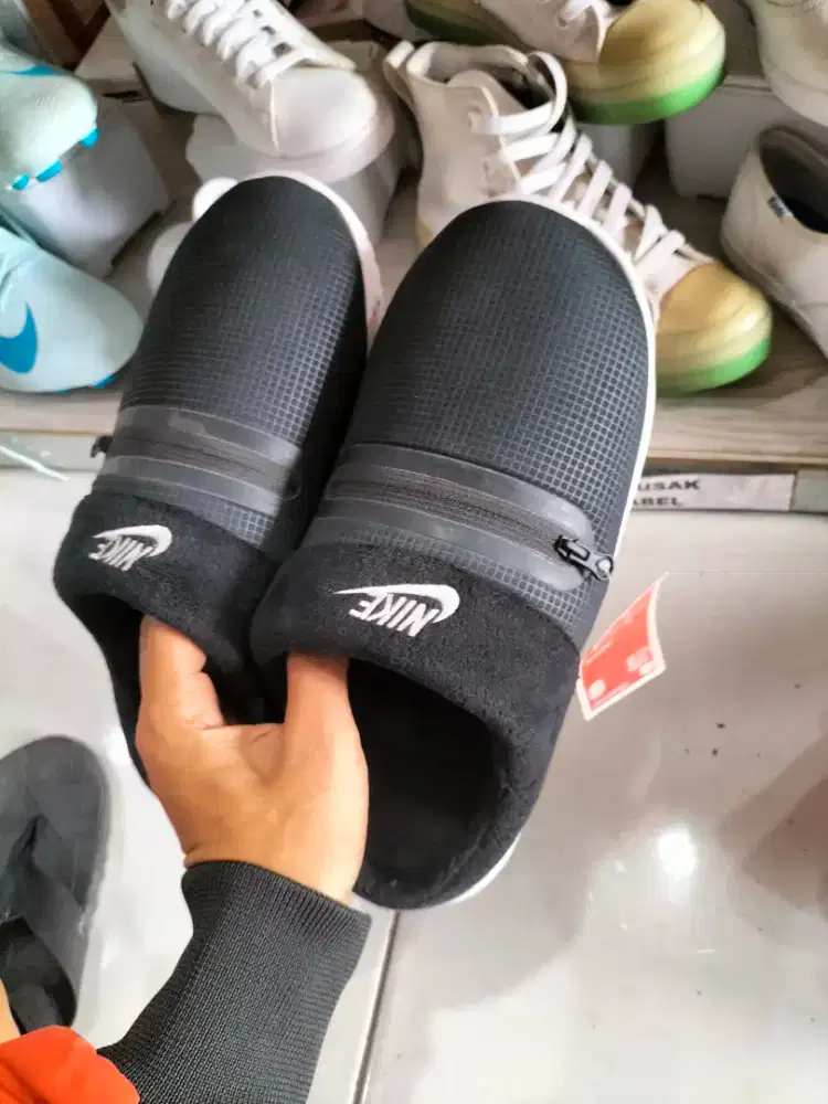 sepasang sandal Nike Burrow warna hitam dengan saku ritsleting