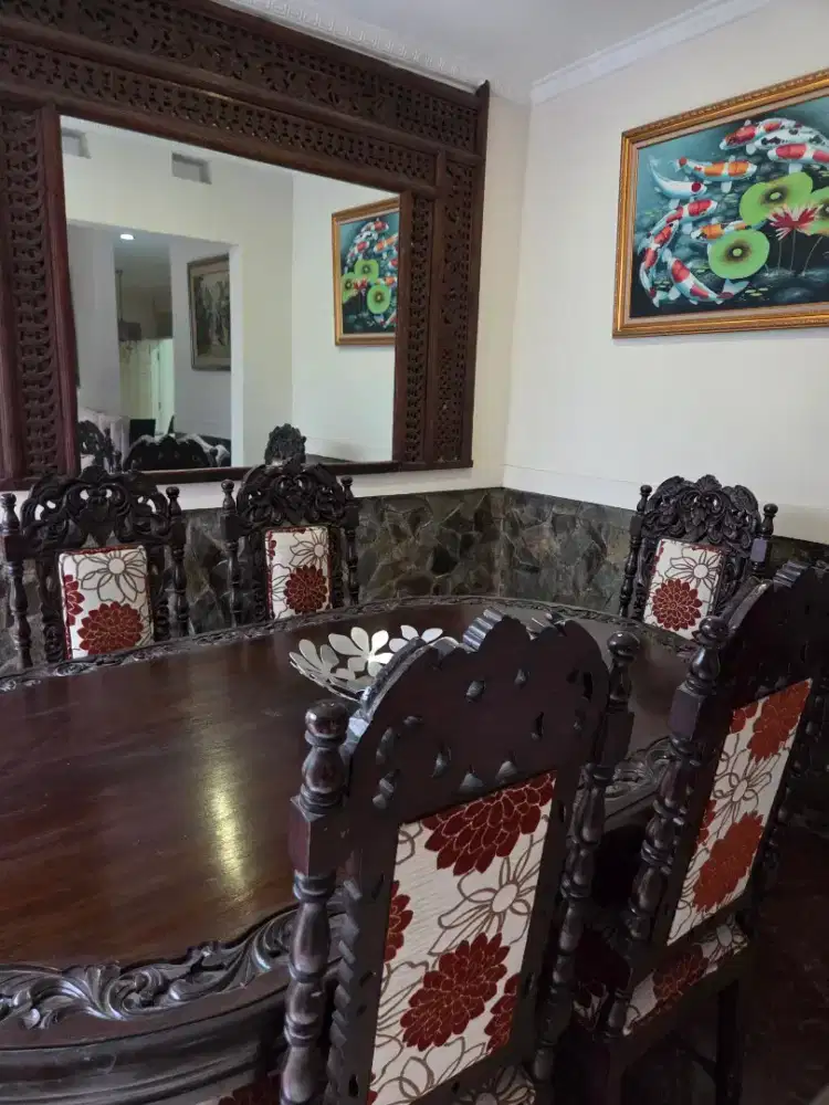 Meja makan dan kursi jati dengan karya seni bernilai tinggi.
