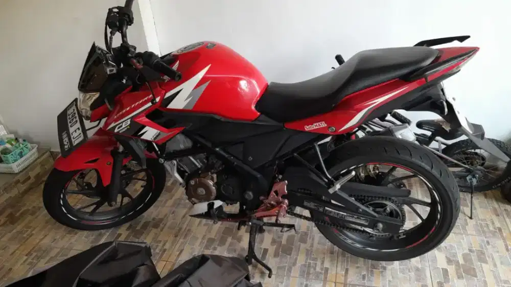Honda CB150R Streetfire berwarna merah dengan grafis putih