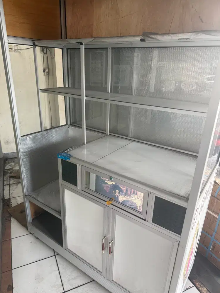 Gerobak jualan makanan. Ada penutup depan. Roda