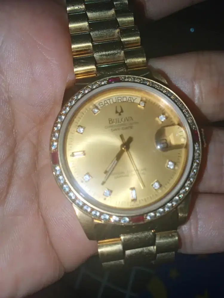 Bulova Chronoprecision Day-Date dengan dial berwarna emas (gold).