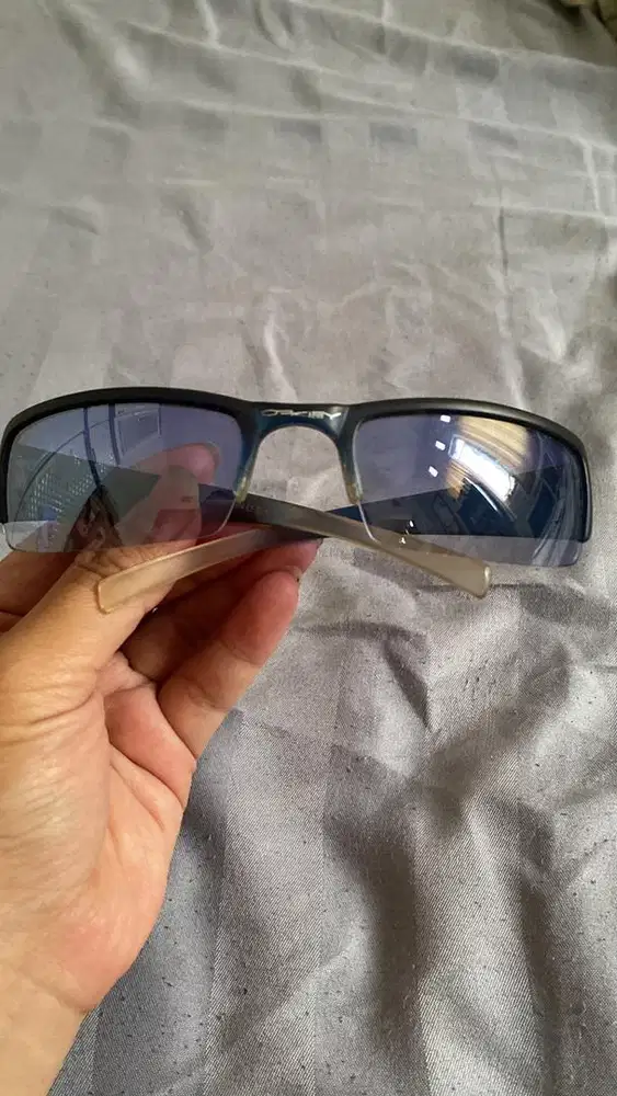 Oakley sunglasses with a dark frame and gradient blue lenses.