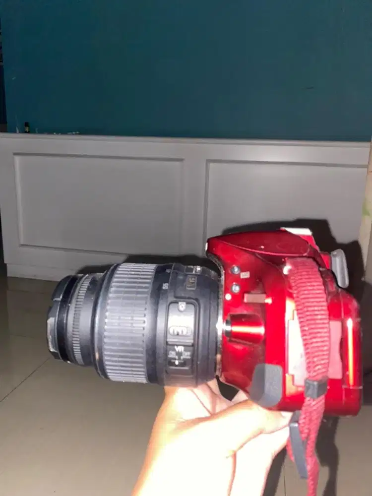 Kamera dan lensa nikon warna merah