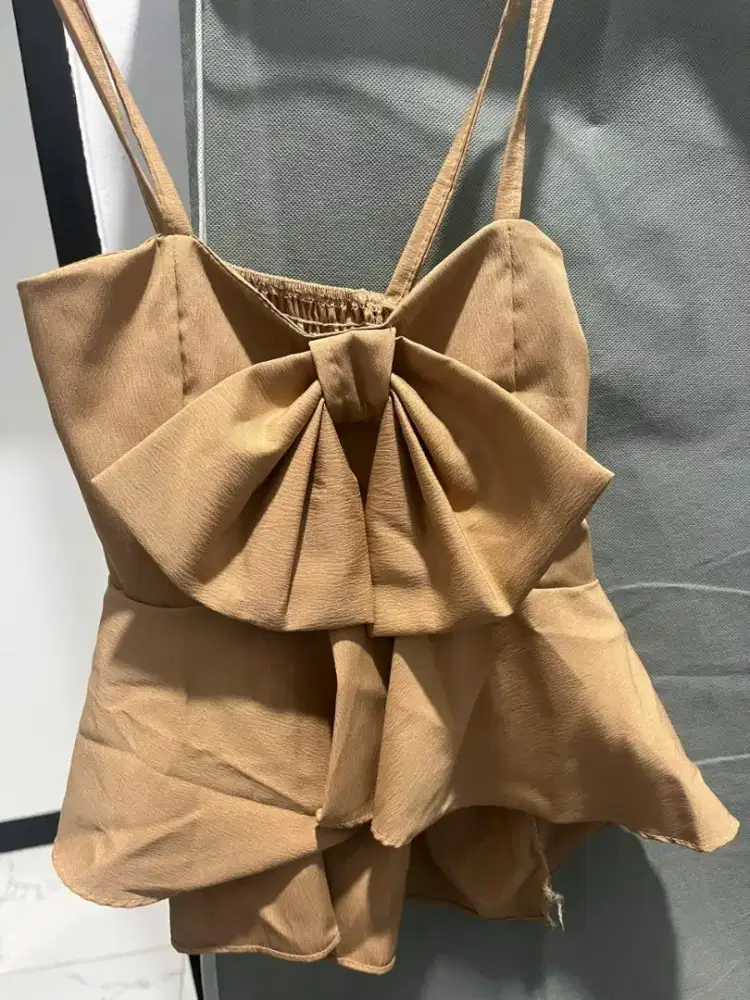 Baju atasan dengan desain pita