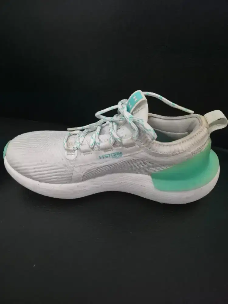 Sepatu golf wanita Under Armour dengan aksen warna pirus (turquoise)