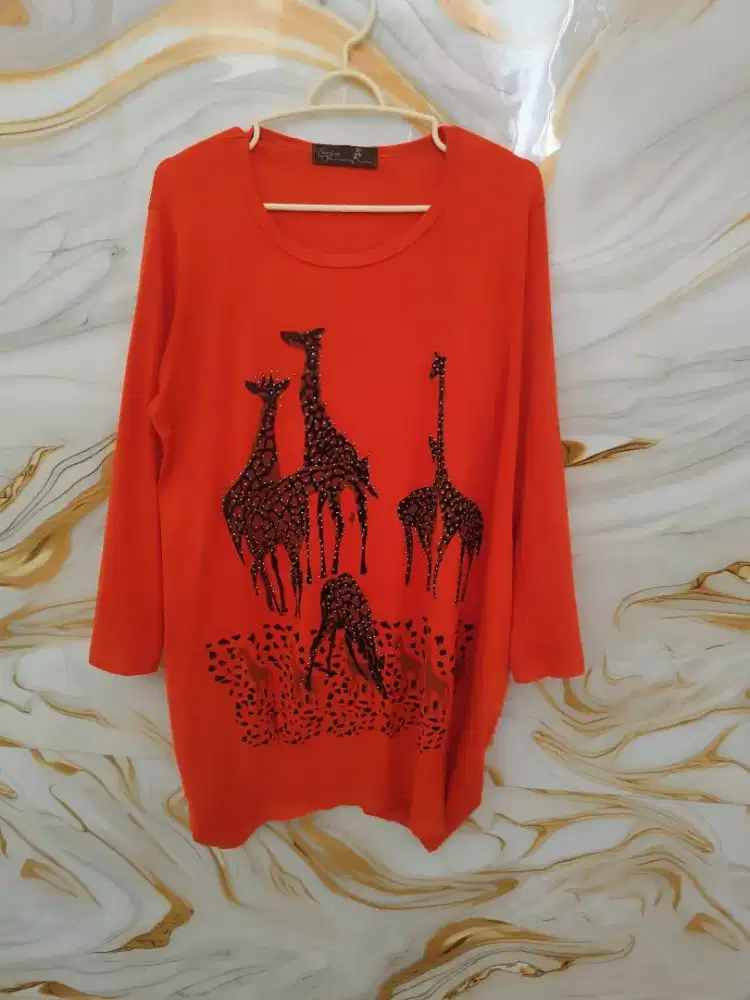 Atasan wanita (blus/kaos tunik) berhiaskan manik-manik (rhinestones)