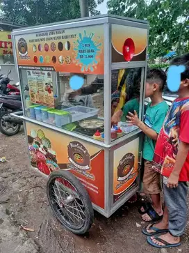 PEDAGANG KELILING MARTABAK MINI DENGAN GEROBAK DORONG