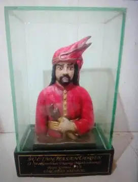Patung hias relief Raja Gowa 16 dalam bingkai kaca.