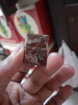Batu gambar motif orang berdiri sama hewan di bawahnya