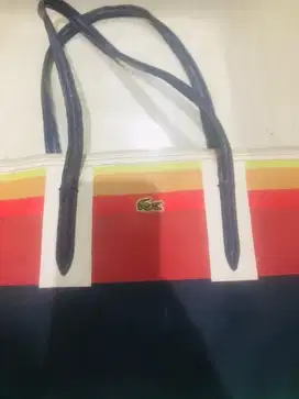 Tas Lacoste ada resleting tengah