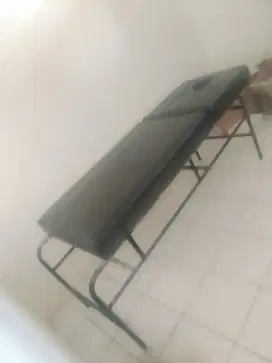 Bed pijat dengan bolongan di kepala