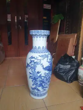 vas atau guci keramik antik dengan motif biru-putih. Vas ini dihiasi