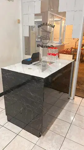 Meja kasir ada kaca tengah nya