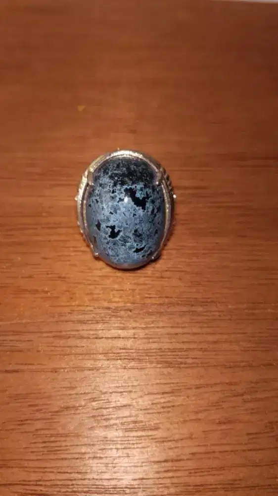 Batu imitasi perhiasan tangan berupa cincin dengan batu berwarna biru