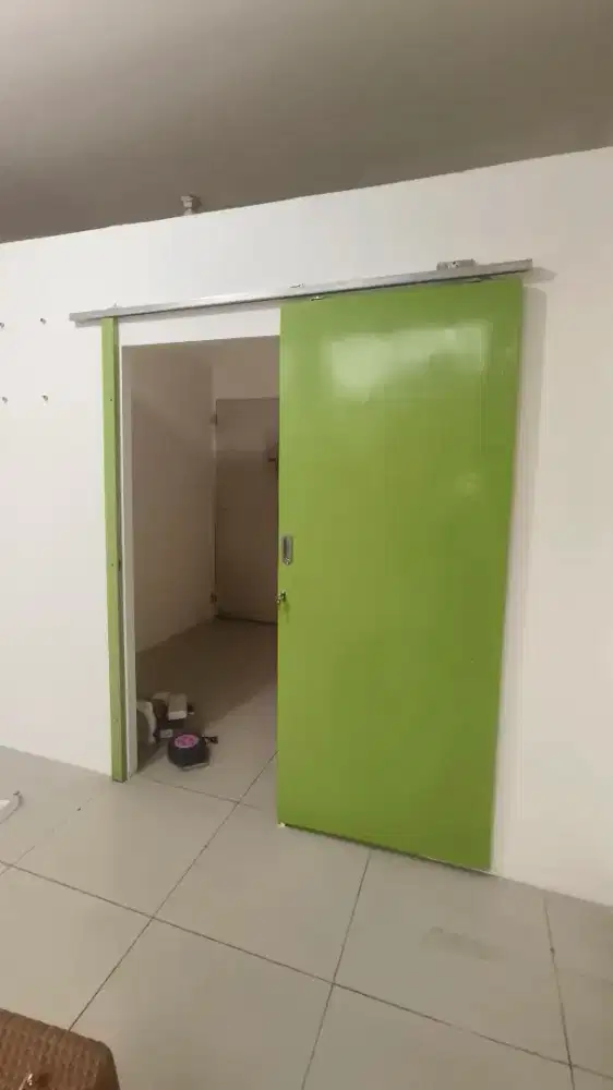 Pintu geser warna hijau lengkap dengan rel nya