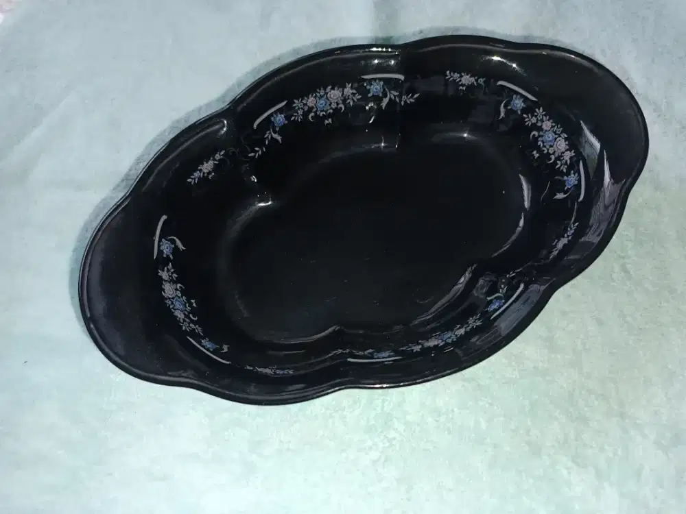 Mangkuk bentuk lonjong warna hitam.