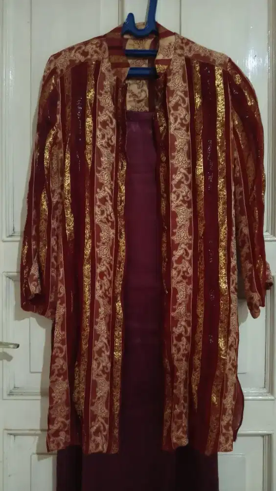 Stelan gaun dg warna kombinasi merah maroon dan emas.