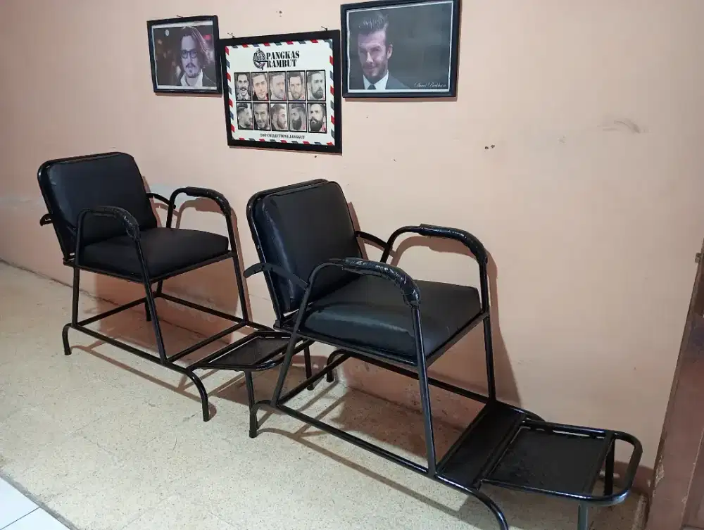 Dua buah kursi pangkas rambut dan poster