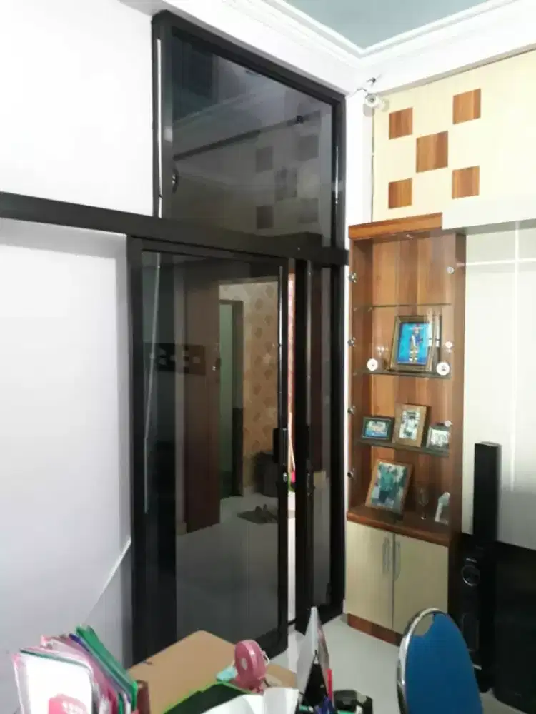 Pintu geser aluminium cokelat kaca bening dan riben awet bergaransi